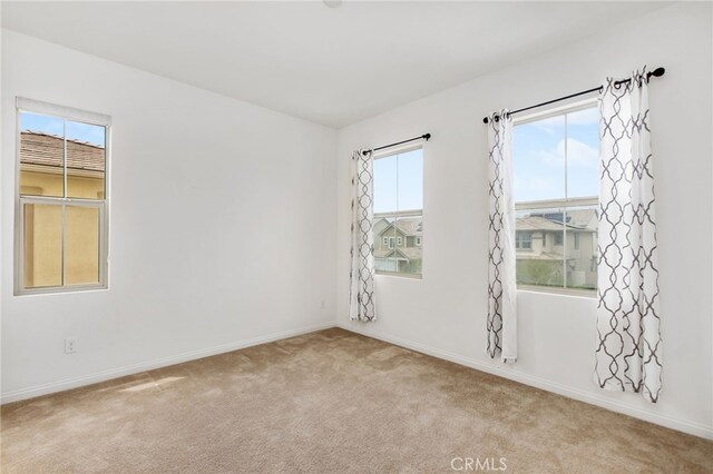 carpeted spare room featuring baseboards