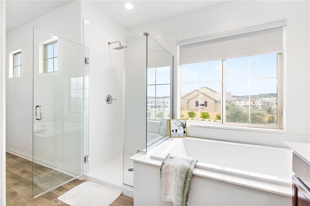bathroom with vanity, wood finished floors, and a stall shower