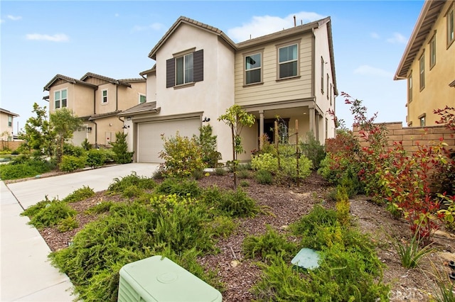 traditional-style house featuring an attached garage, driveway, and stucco siding