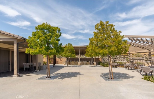 view of patio featuring outdoor dining area, fence, and a pergola