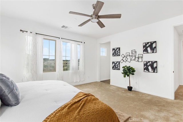 bedroom with light colored carpet, baseboards, visible vents, and a ceiling fan