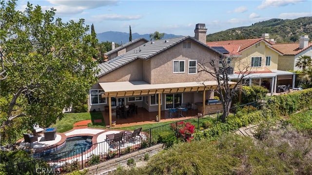 24239 Bella Ct, Newhall, CA 91321 - back of property with stucco siding, a fenced backyard, a mountain view, a chimney, and a patio