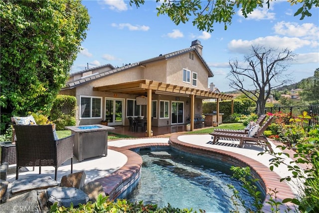 24239 Bella Ct, Newhall, CA 91321 - back of house with stucco siding, a fire pit, a chimney, a ceiling fan, and a patio area