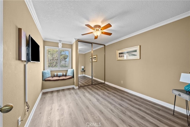 24239 Bella Ct, Newhall, CA 91321 - bedroom featuring wood finished floors, crown molding, a textured ceiling, baseboards, and a closet