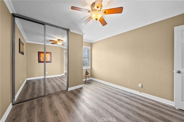 24239 Bella Ct, Newhall, CA 91321 - unfurnished bedroom featuring wood finished floors, crown molding, a closet, a textured ceiling, and ceiling fan