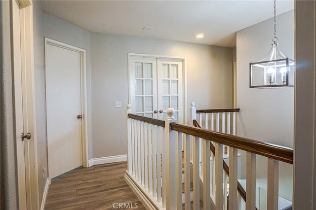 corridor with baseboards, dark wood-type flooring, recessed lighting, and an upstairs landing