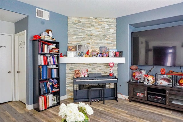 interior space featuring baseboards, wood finished floors, and visible vents