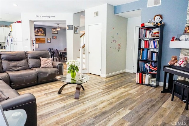 living room featuring visible vents, stairs, wood finished floors, baseboards, and recessed lighting