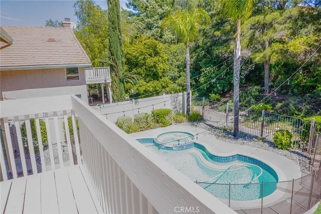 view of pool featuring a fenced backyard and a pool with connected hot tub