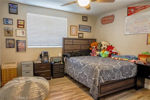 bedroom featuring multiple windows, a ceiling fan, and wood finished floors