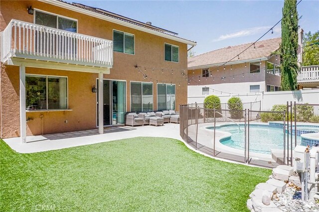 exterior space with an outdoor living space, a pool with connected hot tub, fence, a yard, and stucco siding