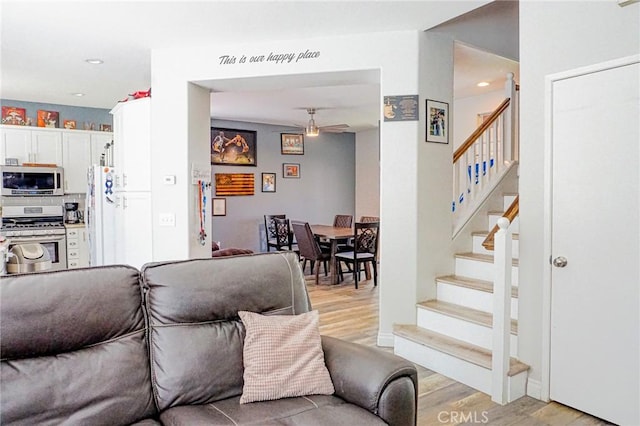 living area featuring stairway, ceiling fan, recessed lighting, and light wood-style flooring