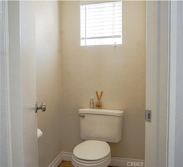 bathroom featuring baseboards and toilet