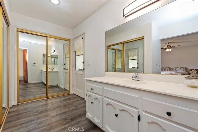 full bathroom with a ceiling fan, wood finished floors, vanity, baseboards, and ensuite bath