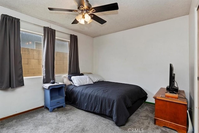 carpeted bedroom featuring baseboards, ceiling fan, and a textured ceiling