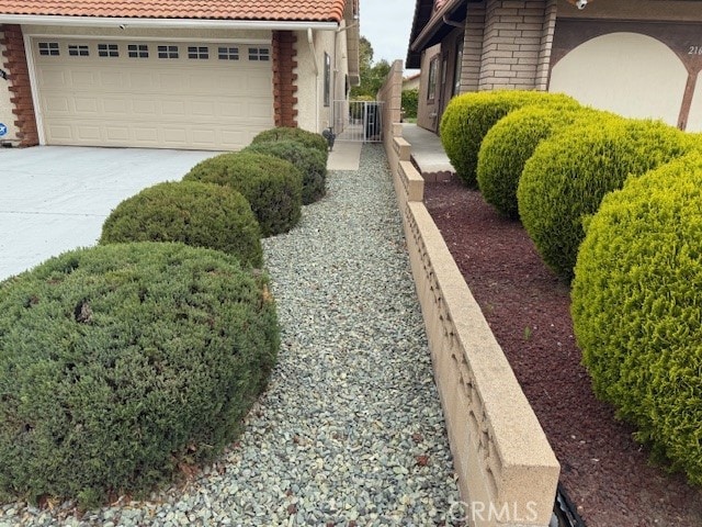 view of home's exterior featuring a tiled roof and concrete driveway