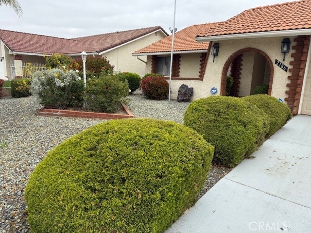 exterior space with a tiled roof and stucco siding