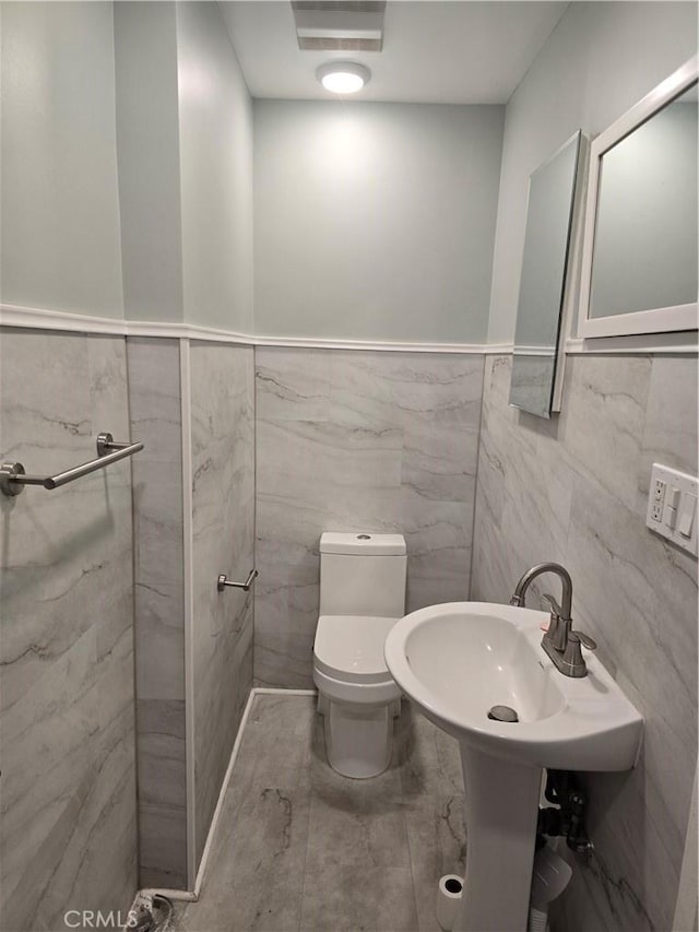 624 Cedar Ave, Long Beach, CA 90802 - half bathroom featuring tile walls and wainscoting