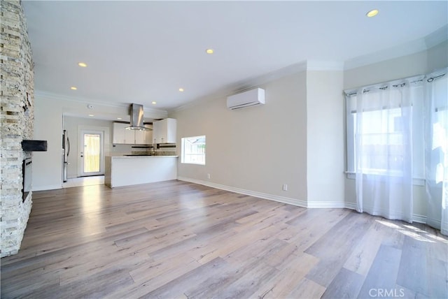 624 Cedar Ave, Long Beach, CA 90802 - unfurnished living room featuring a wall mounted air conditioner, crown molding, light wood finished floors, and recessed lighting