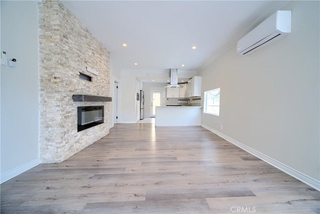 624 Cedar Ave, Long Beach, CA 90802 - unfurnished living room with an AC wall unit, a fireplace, ornamental molding, light wood-style floors, and recessed lighting