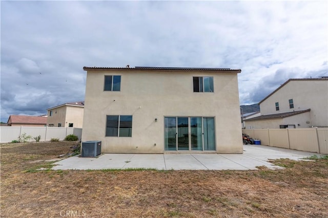 back of house with a patio, central AC, fence, and stucco siding