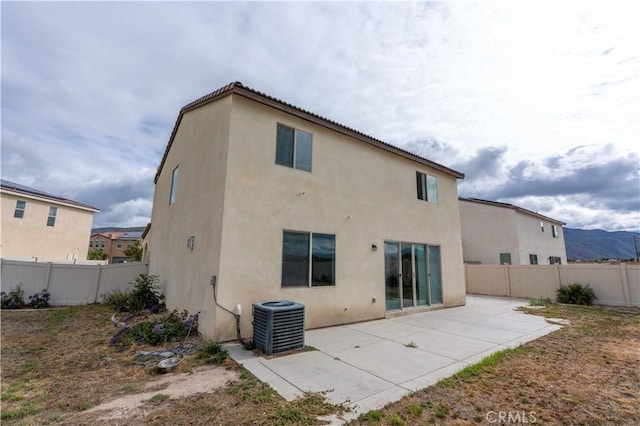 back of house featuring central air condition unit, a patio, stucco siding, and a fenced backyard