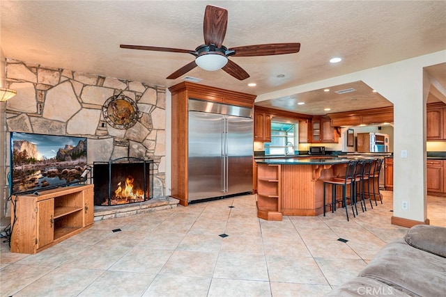 2136 Forbes Ave, Claremont, CA 91711 - kitchen featuring ceiling fan, dark countertops, open shelves, brown cabinets, and stainless steel built in refrigerator