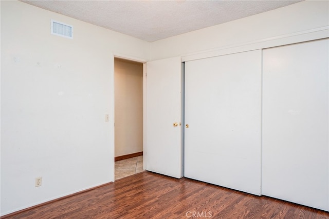 2136 Forbes Ave, Claremont, CA 91711 - unfurnished bedroom featuring visible vents, a textured ceiling, wood finished floors, and a closet