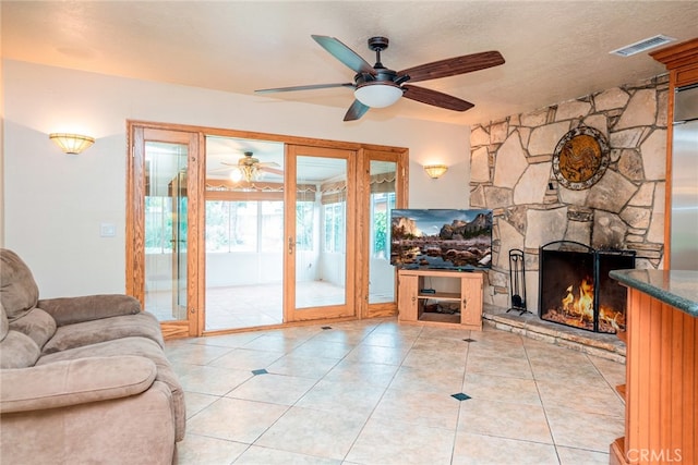 2136 Forbes Ave, Claremont, CA 91711 - tiled living area featuring a ceiling fan, a stone fireplace, and visible vents