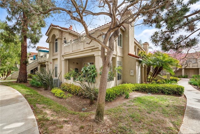 112 Cinnamon Teal, Aliso Viejo, CA 92656 - view of home's exterior featuring stucco siding, stairs, a tiled roof, and a chimney