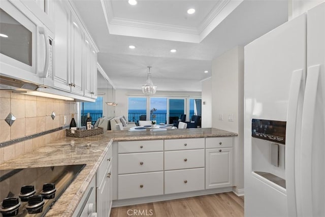24242 Santa Clara Ave Unit 26, Dana Point, CA 92629 - kitchen with white appliances, a tray ceiling, white cabinets, tasteful backsplash, and light wood-style flooring