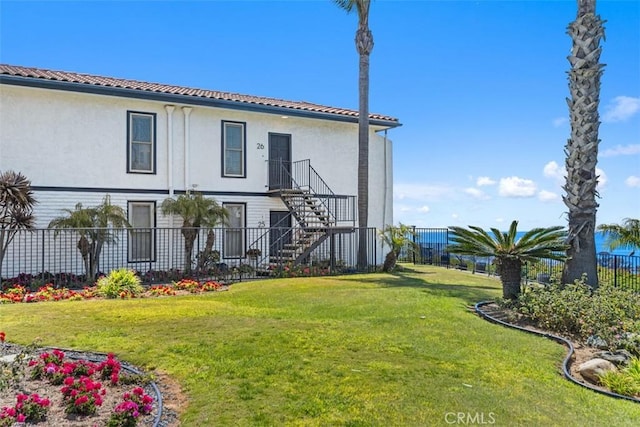24242 Santa Clara Ave Unit 26, Dana Point, CA 92629 - back of property with a tile roof, a lawn, stairway, a fenced backyard, and stucco siding