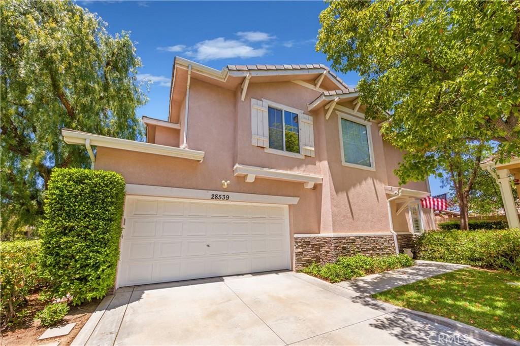 28539 Calex Dr, Valencia, CA 91381 - view of front of house with driveway, stone siding, and stucco siding