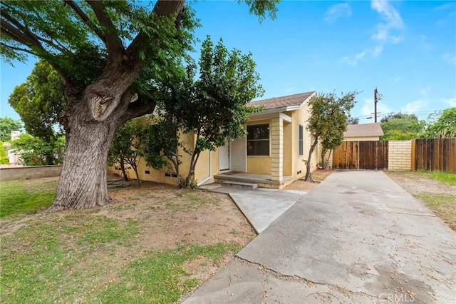 view of front of home with fence, a patio, stucco siding, and concrete driveway