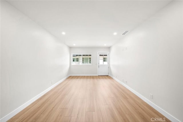 unfurnished room with baseboards, recessed lighting, light wood finished floors, and visible vents