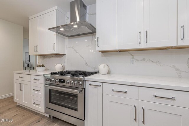 313 N Sunnyside Ave, Sierra Madre, CA 91024 - kitchen with decorative backsplash, white cabinetry, high end stainless steel range, and wall chimney range hood