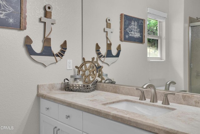 full bathroom with vanity and a shower with door