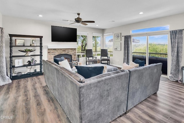 living room with a healthy amount of sunlight, a fireplace, a ceiling fan, and wood finished floors