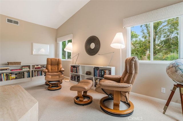 living area with carpet flooring, baseboards, visible vents, and high vaulted ceiling