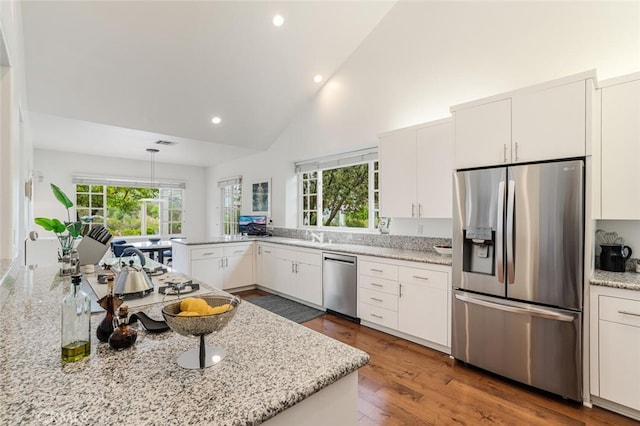 kitchen with high vaulted ceiling, stainless steel appliances, recessed lighting, white cabinetry, and wood finished floors