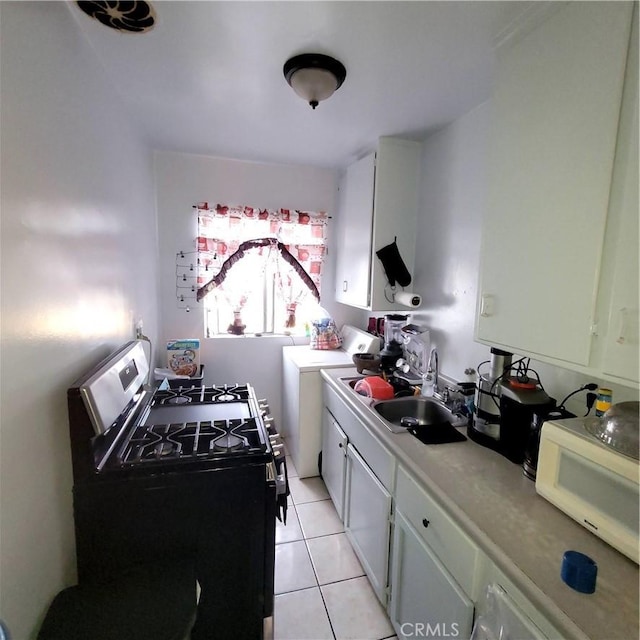 kitchen with stainless steel gas stove, white microwave, light countertops, a sink, and independent washer and dryer