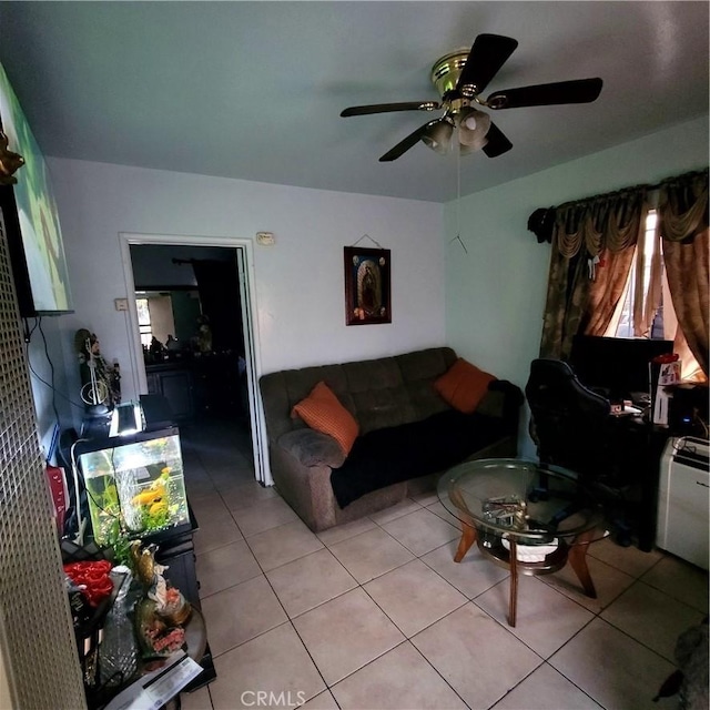 living area featuring a ceiling fan, light tile patterned floors, and a healthy amount of sunlight