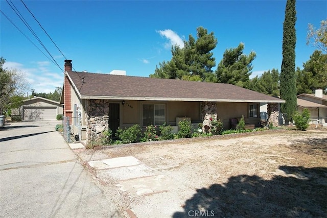 7486 Earhart Ave, Hesperia, CA 92345 - view of side of property featuring stone siding, a garage, an outbuilding, and a chimney