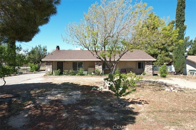 7486 Earhart Ave, Hesperia, CA 92345 - single story home with a chimney, stone siding, fence, and stucco siding