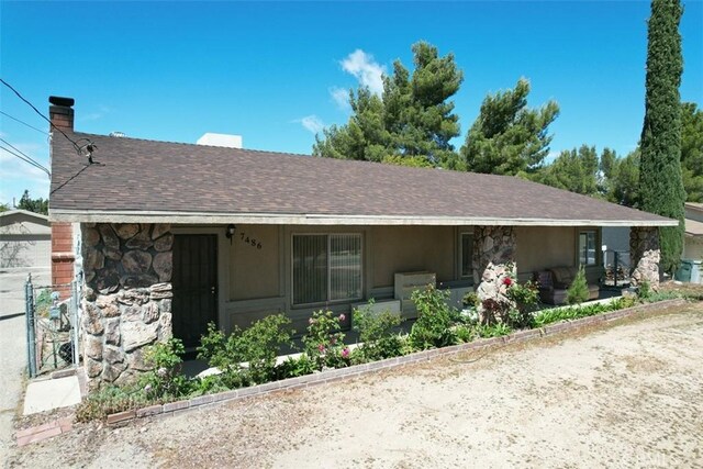 7486 Earhart Ave, Hesperia, CA 92345 - ranch-style house featuring stone siding, a chimney, covered porch, and roof with shingles
