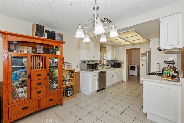 7486 Earhart Ave, Hesperia, CA 92345 - kitchen featuring stainless steel appliances, washer / dryer, light countertops, a chandelier, and a textured ceiling