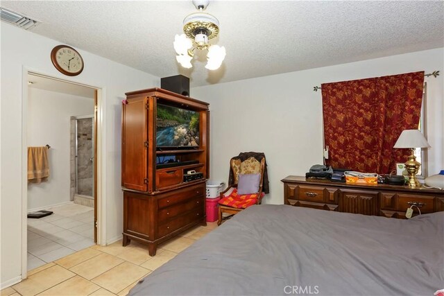 7486 Earhart Ave, Hesperia, CA 92345 - bedroom with a chandelier, light tile patterned flooring, a textured ceiling, and ensuite bath