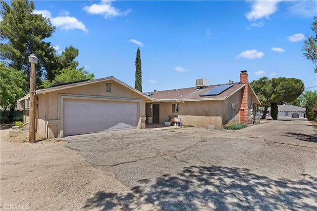 7486 Earhart Ave, Hesperia, CA 92345 - single story home featuring solar panels, an attached garage, stucco siding, driveway, and central air condition unit