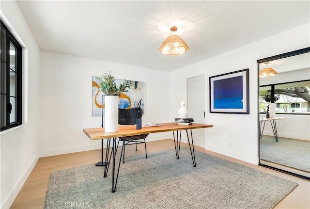 office space featuring baseboards and light wood finished floors