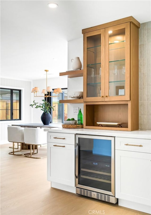 bar featuring light wood-type flooring and wine cooler